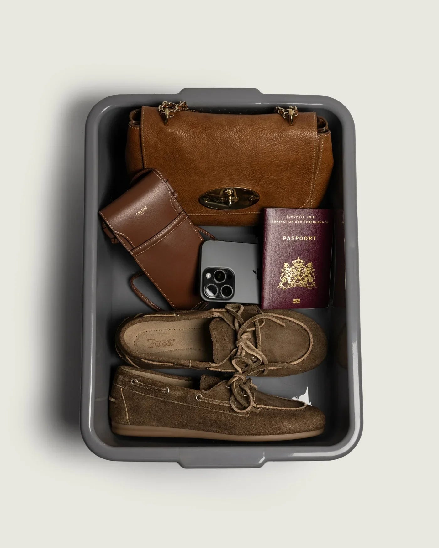 Reise-Flatlay mit Loafern in braunem Wildleder neben Tasche, Smartphone und Reisepass von Posa.