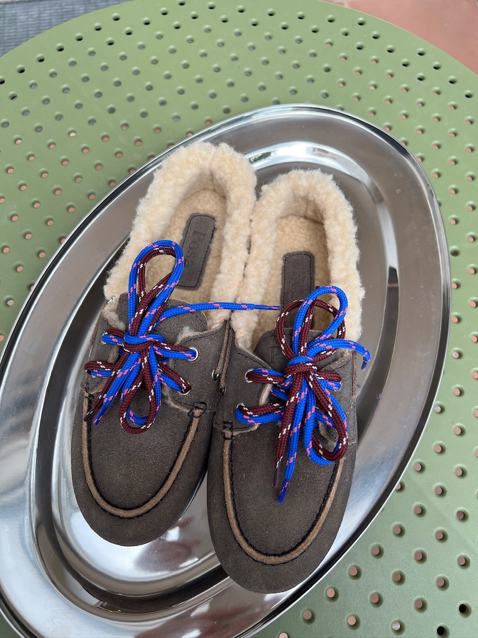 Weinrote Posa Schnürsenkel mit hellblauen Akzenten, eingefädelt in einen braunen Loafer.