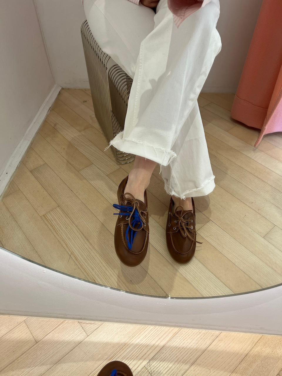 Model trägt den Boat Loafer Brushed Brown von Posa zu weißer Cropped-Jeans, sitzend fotografiert.