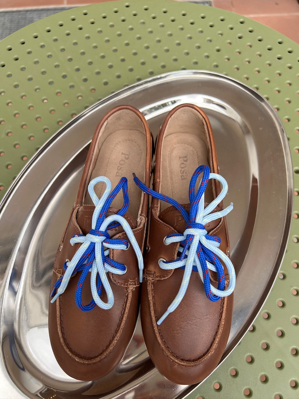Kobaltblaue Posa Schnürsenkel mit Farbakzent, eingefädelt in einen braunen Loafer.